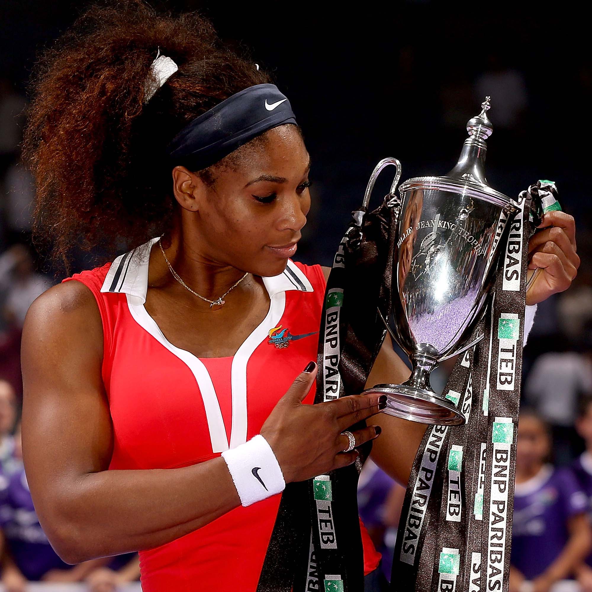Serena Williams lifts the WTA Finals Trophy made by Thomas Lyte