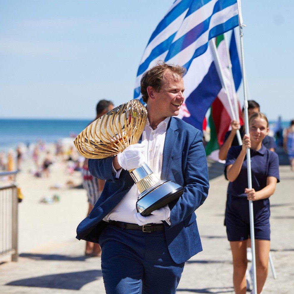 Stephen Farrow walking with the United Cup trophy designed and made by Thomas Lyte